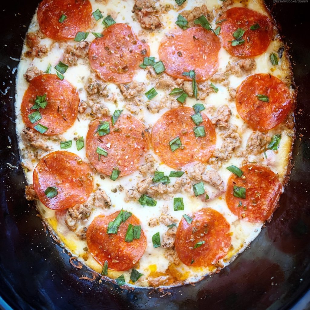 overhead shot of cooked pizza chicken in a black slow cooker