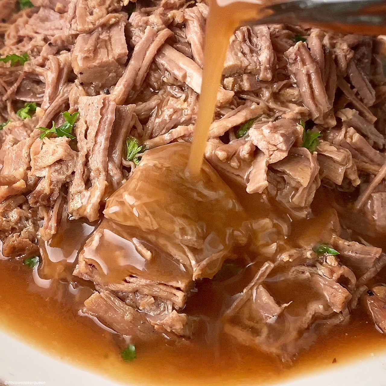 shredded brisket with gravy being poured on top