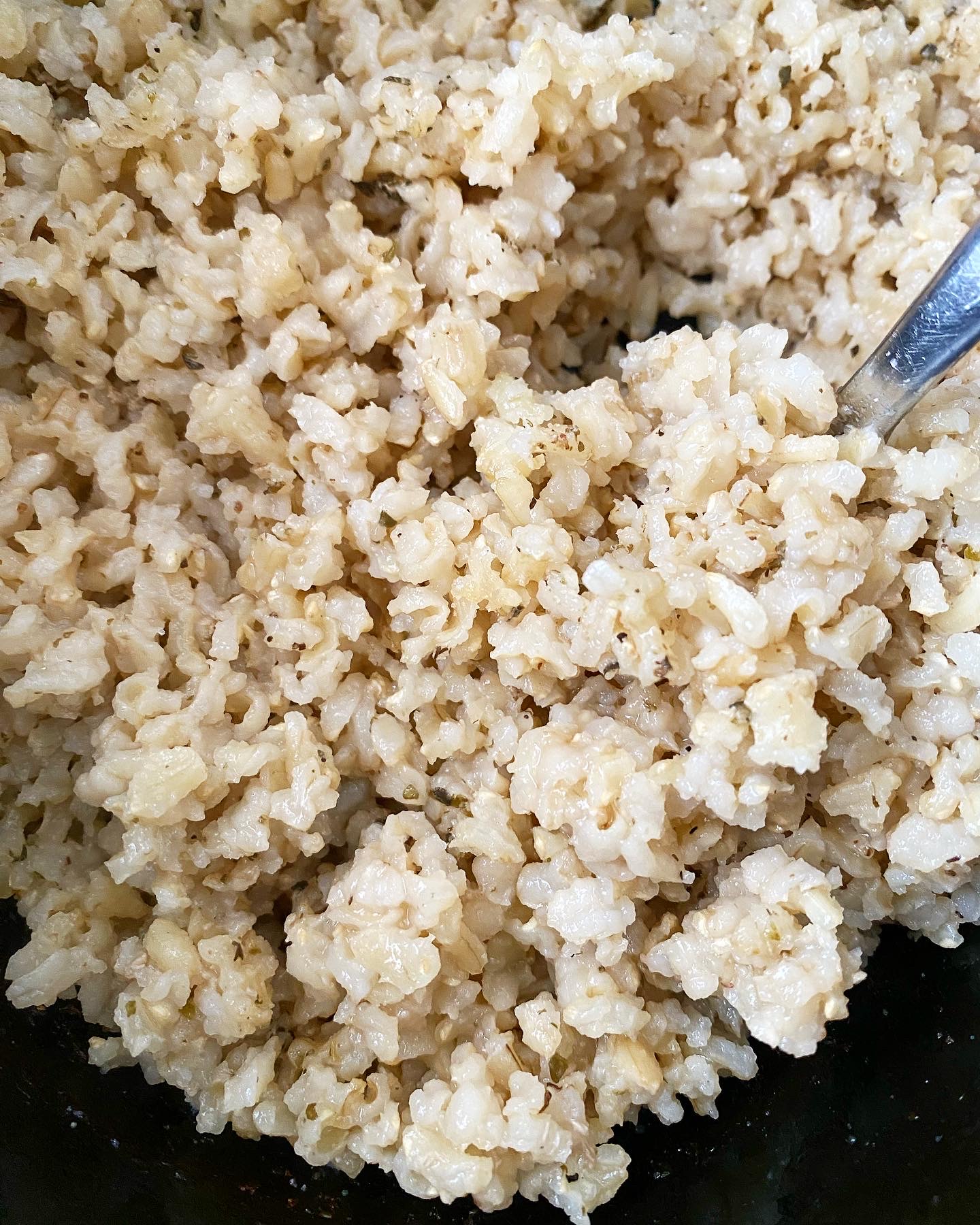 overhead close up shot of uncooked rice in a black crockpot