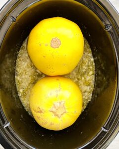 overhead shot of uncooked spaghetti squash in a black slow cooker