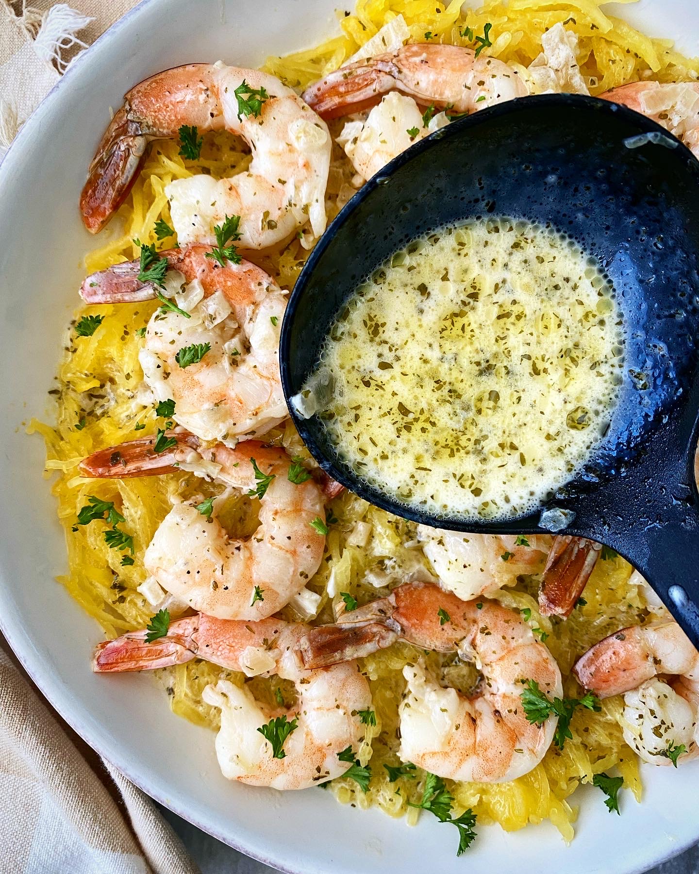 cooked spaghetti squash shrimp scampi with sauce being poured on top