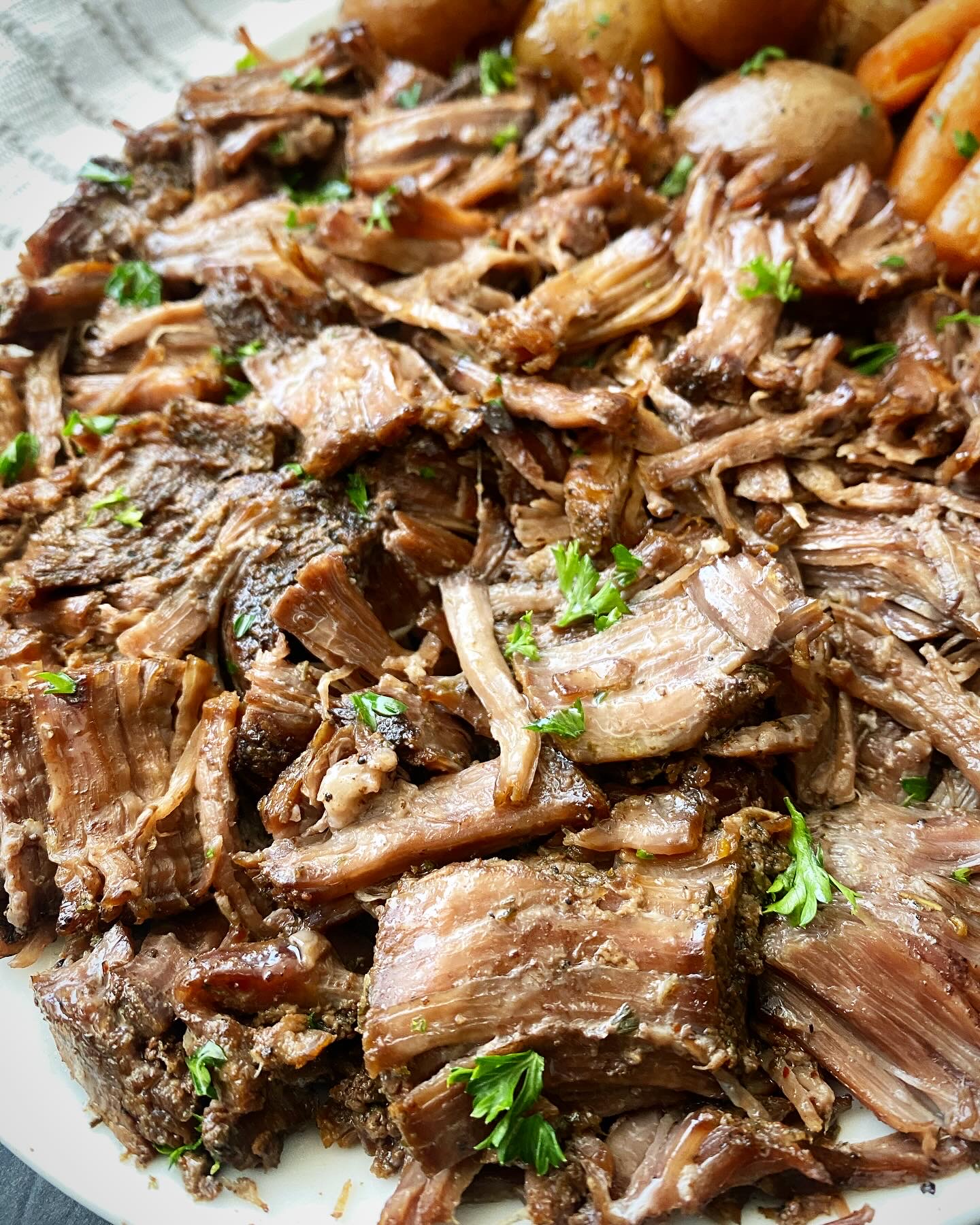 close up shot of cooked beef roast on a white platter 