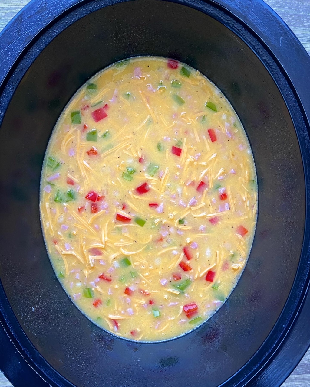 overhead shot of uncooked Slow Cooker Denver 'Omelette' Casserole in a black slow cooker