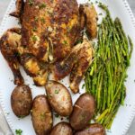 overhead shot of whole chicken dinner on a white platter