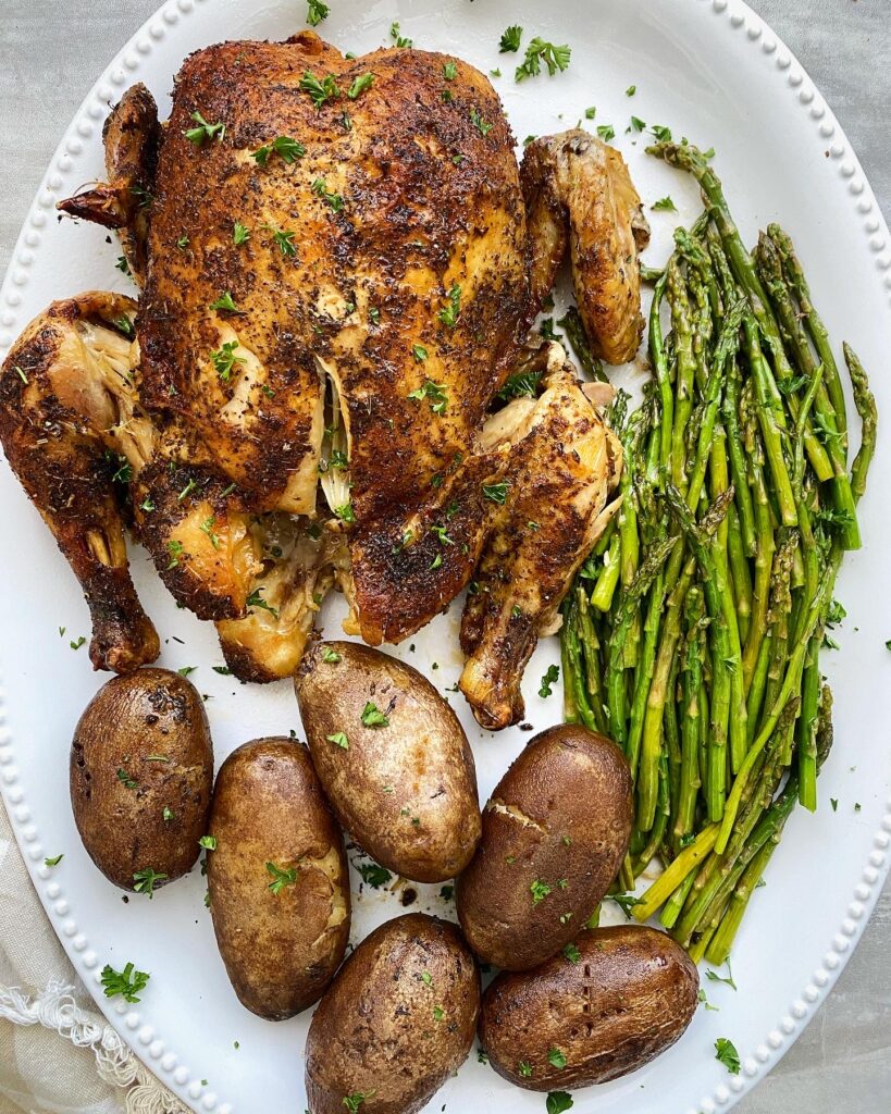 overhead shot of whole chicken dinner on a white platter