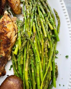 close up shot of cooked asparagus on a white platter