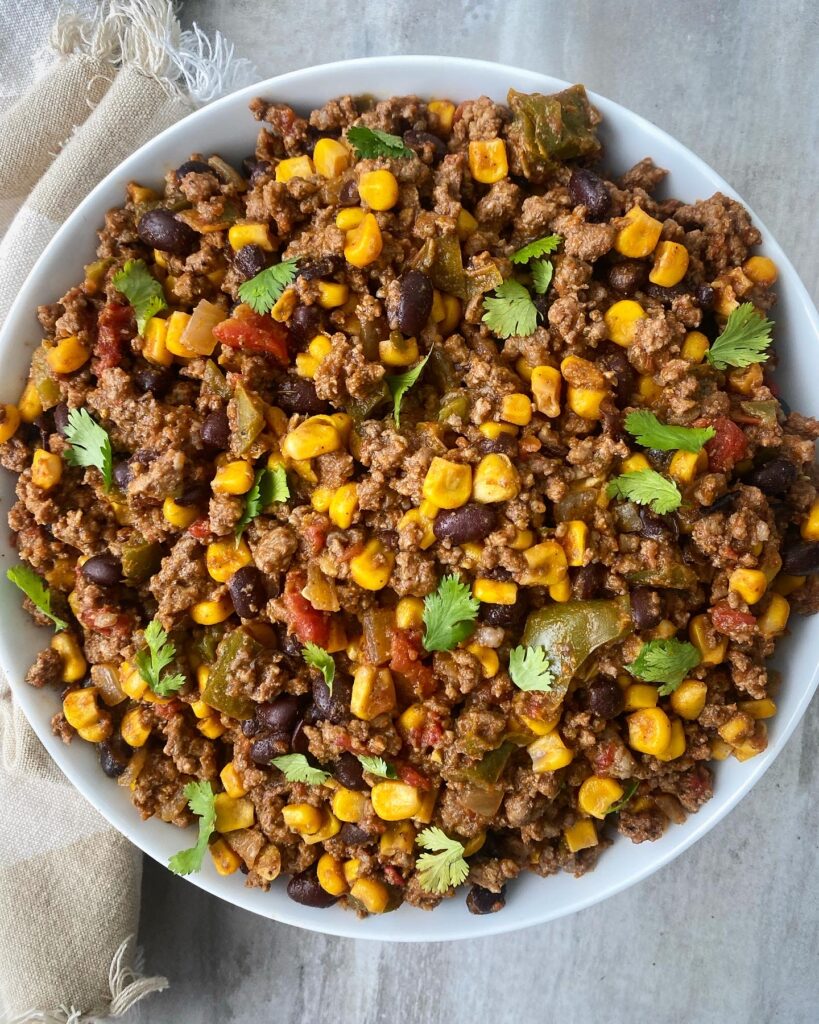 overhead shot of cooked crockpot Tex-Mex ground meat in a white bowl