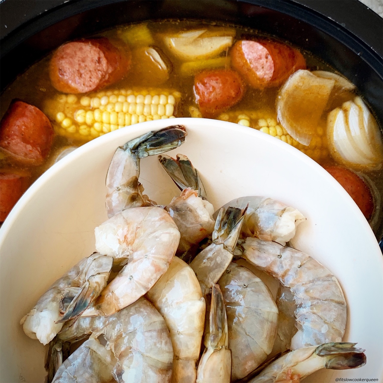 adding shrimp to the slow cooker for low country boil