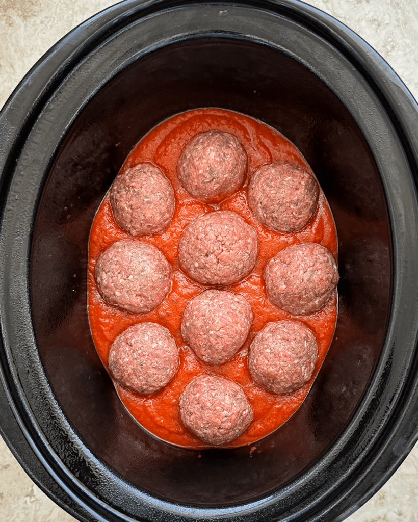 close up shot of cooked stuffed mozzarella stuffed meatballs in the slow cooker