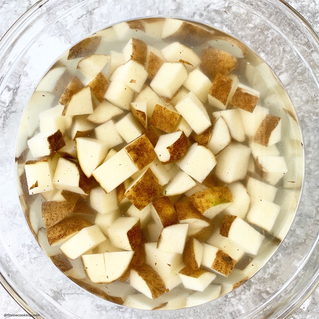raw potatoes in a bowl soaking in water