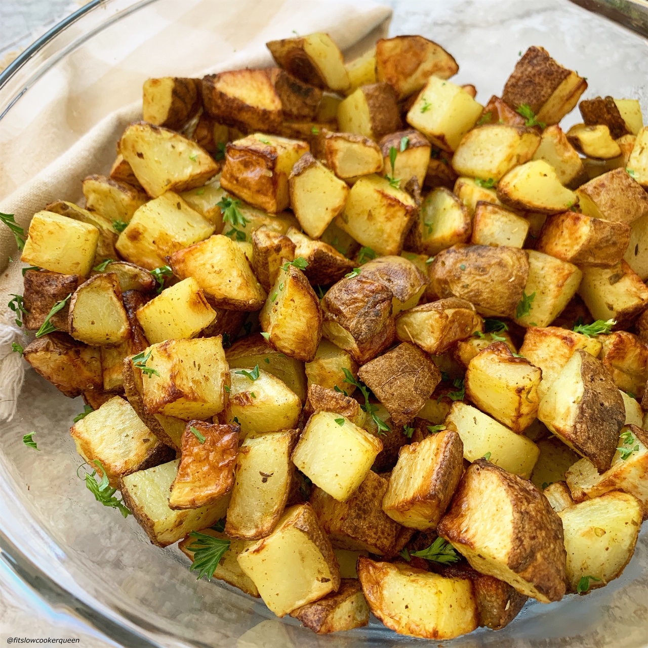 air fryer whole30 breakfast potatoes in a bowl topped with chopped parsley