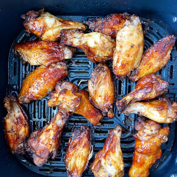 overhead shot of cooked marinated chicken wings in the air fryer basket