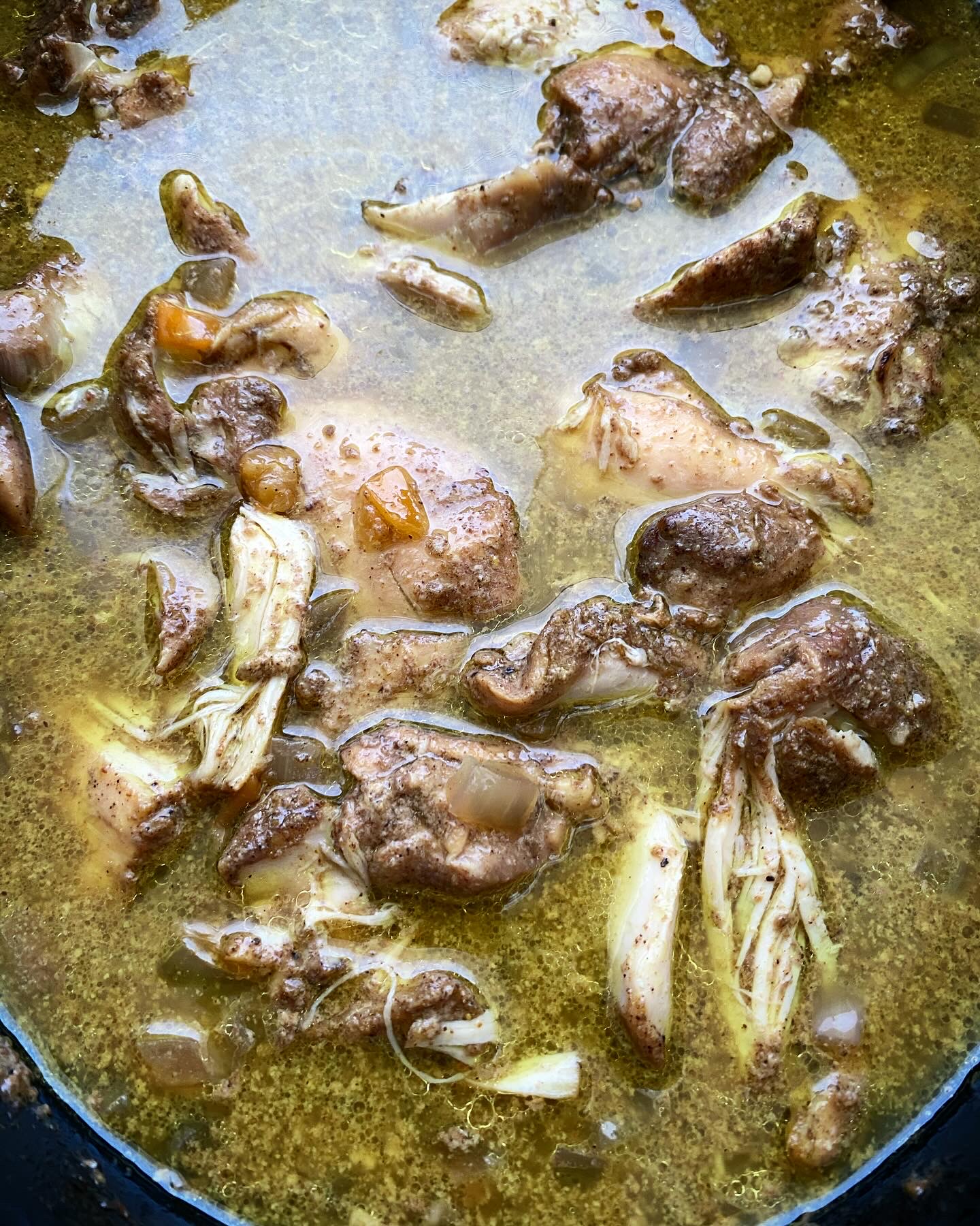 overhead shot of cooked Caribbean chicken in a black slow cooker