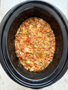 close up shot overhead shot of cooked slow cooker unstuffed cabbage rolls in a black slow cookerof slow cooker unstuffed cabbage rolls in a white bowl