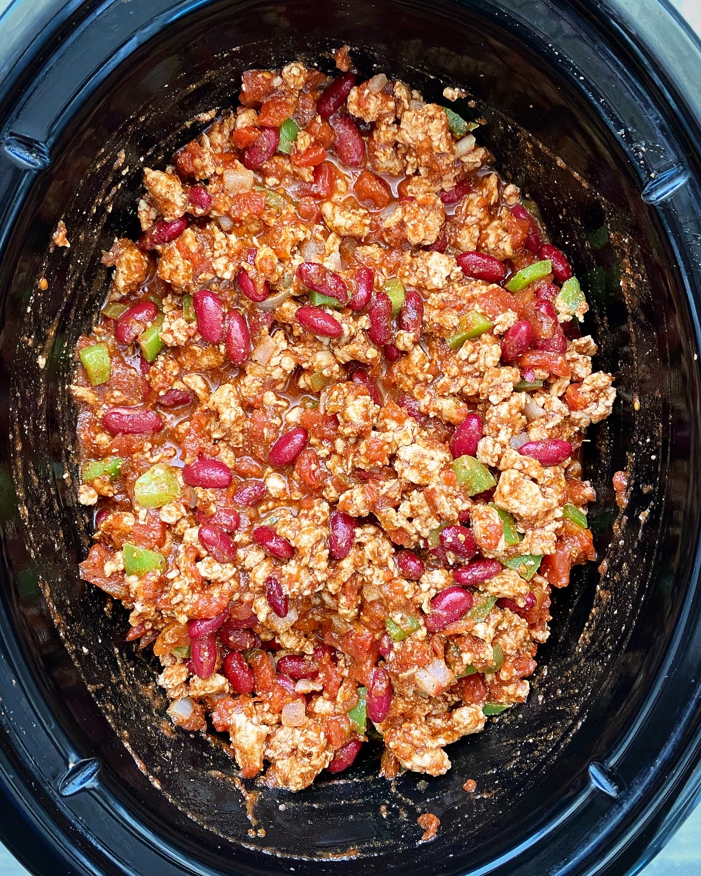 uncooked turkey chili in a black slow cooker