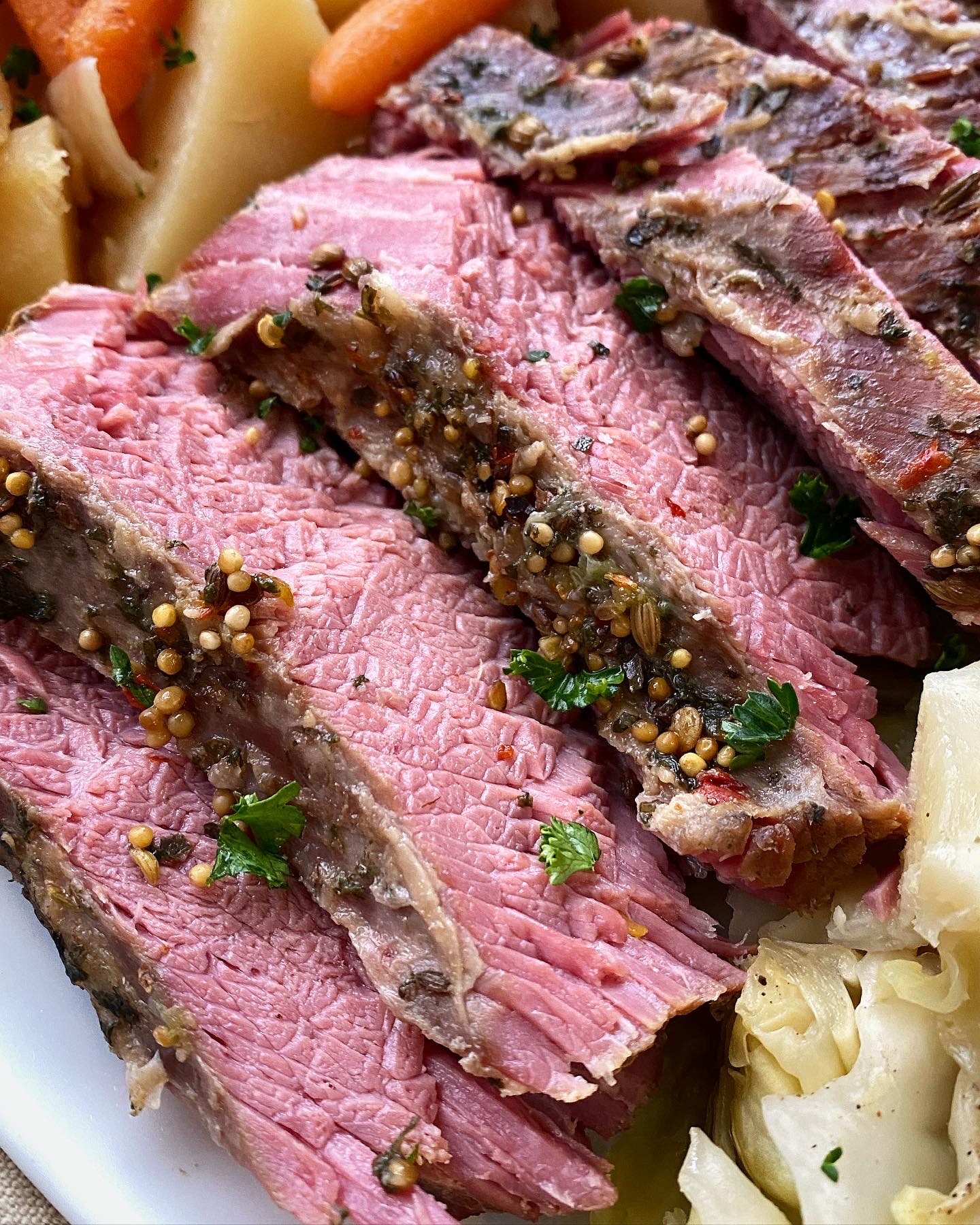 close up shot of cooked corned beef on a white platter