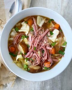 overhead shot of corned beef & cabbage soup in a white bowl