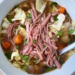 overhead shot of corned beef & cabbage soup in a white bowl