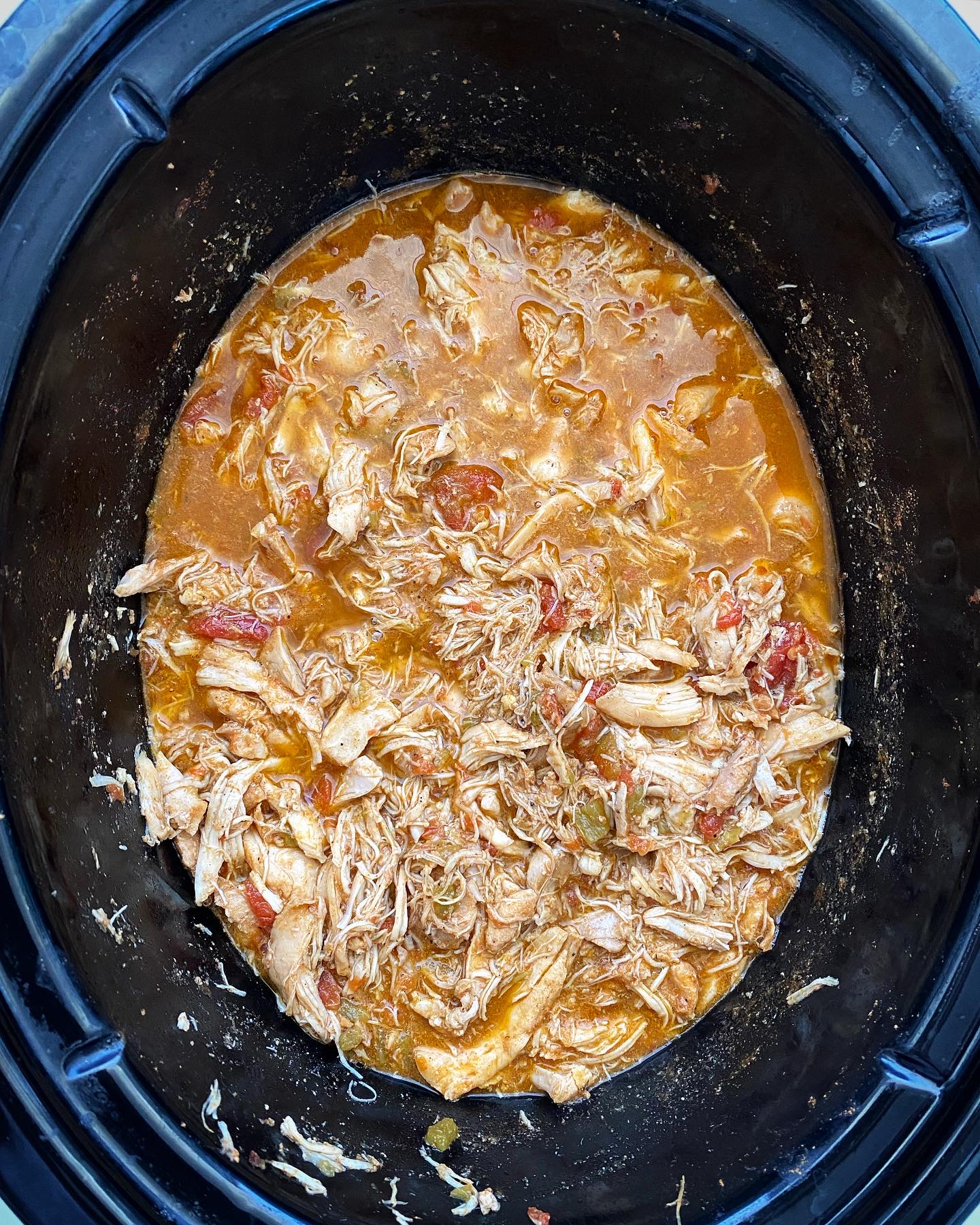overhead shot of easy crockpot chicken tacos in a black slow cooker