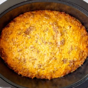 overhead shot of cooked cheeseburger casserole in a black slow cooker