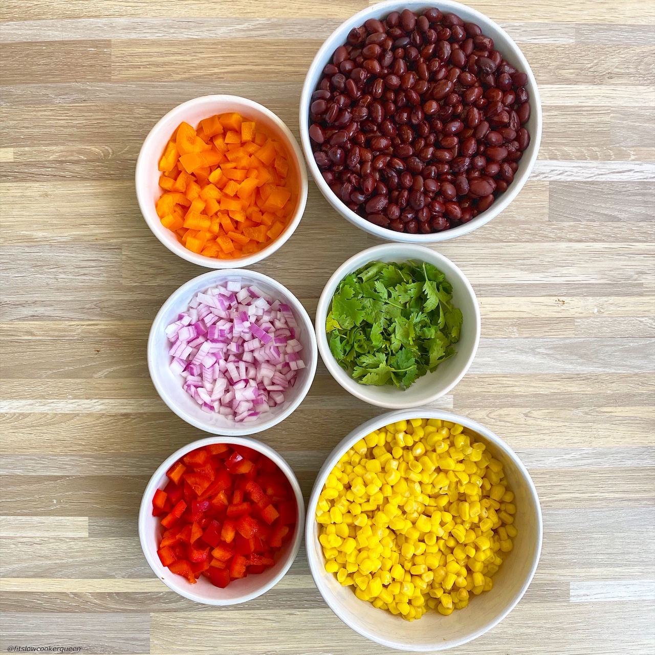 in separate bowls: black beans, corn, diced orange bell pepper, diced red bell pepper, red onion, fresh cilantro