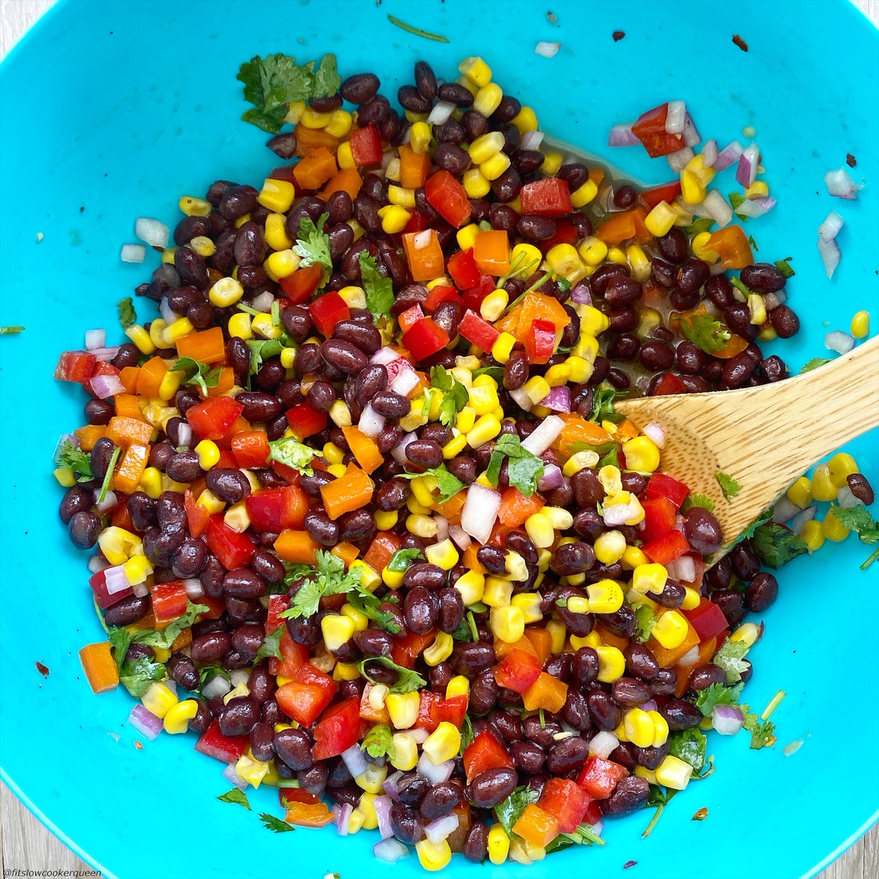 Mixed together in a large bowl: black beans, corn, diced orange bell pepper, diced red bell pepper, red onion, fresh cilantro