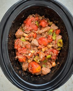 overhead shot of uncooked Beef Chili Stew in a black slow cooker