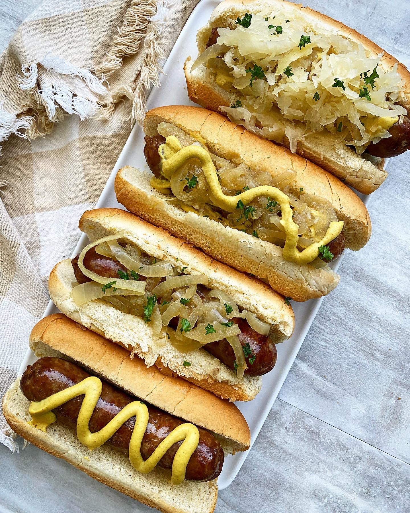 overhead shot of beer brats in buns with condiments