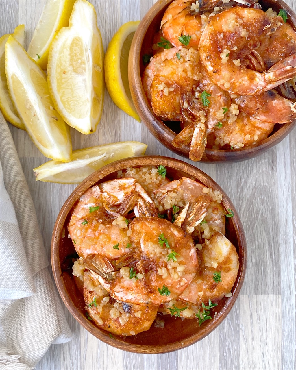 top view of cooked hawaiian shrimp with garlic on top in two separate bowls