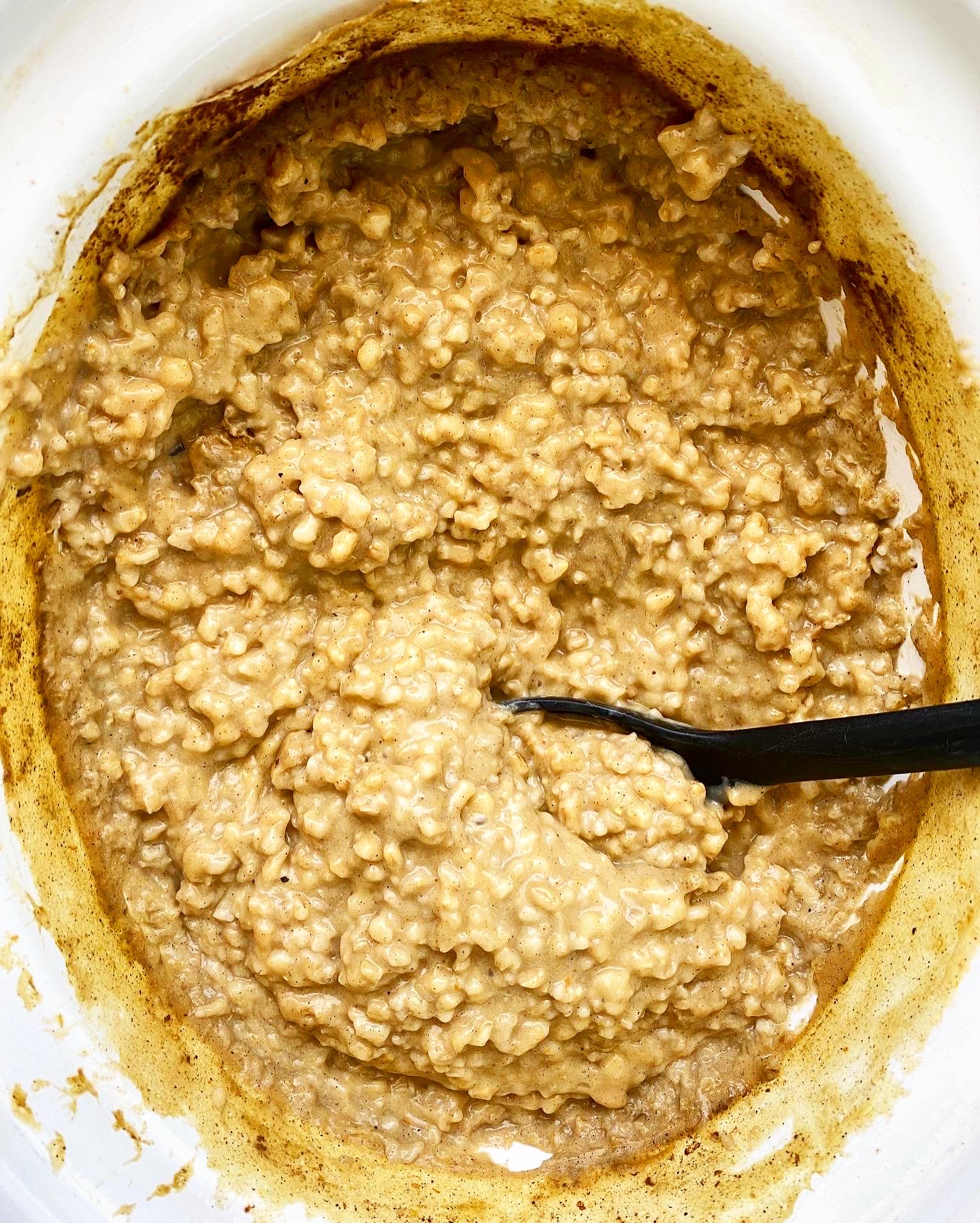 overhead shot of cooked pumpkin oatmeal in a white slow cooker