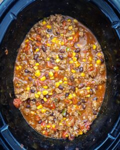 overhead shot of cooked chorizo beef chili in a black slow cooker