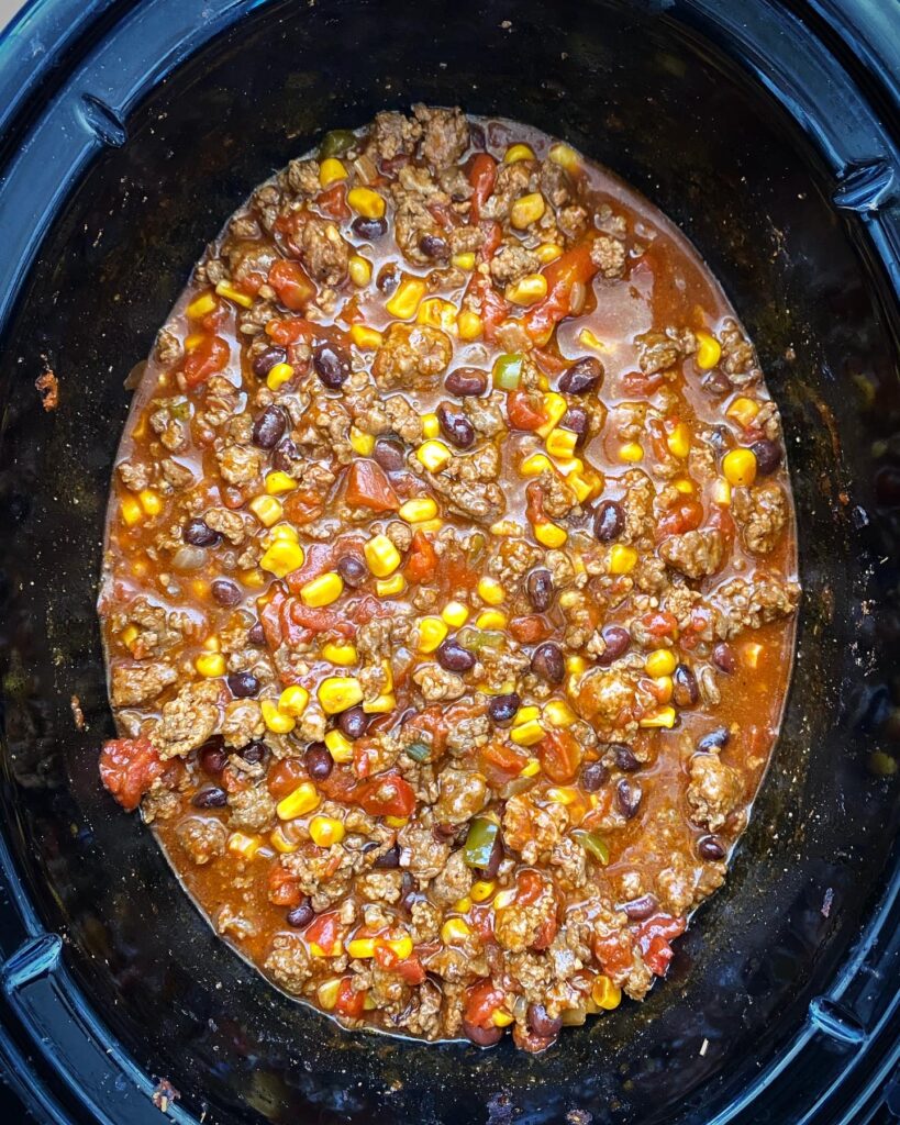 overhead shot of cooked chorizo beef chili in a black slow cooker