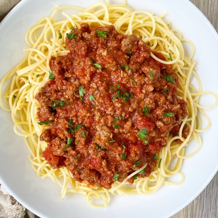 Slow Cooker Spaghetti Sauce on a white plate served over noodles