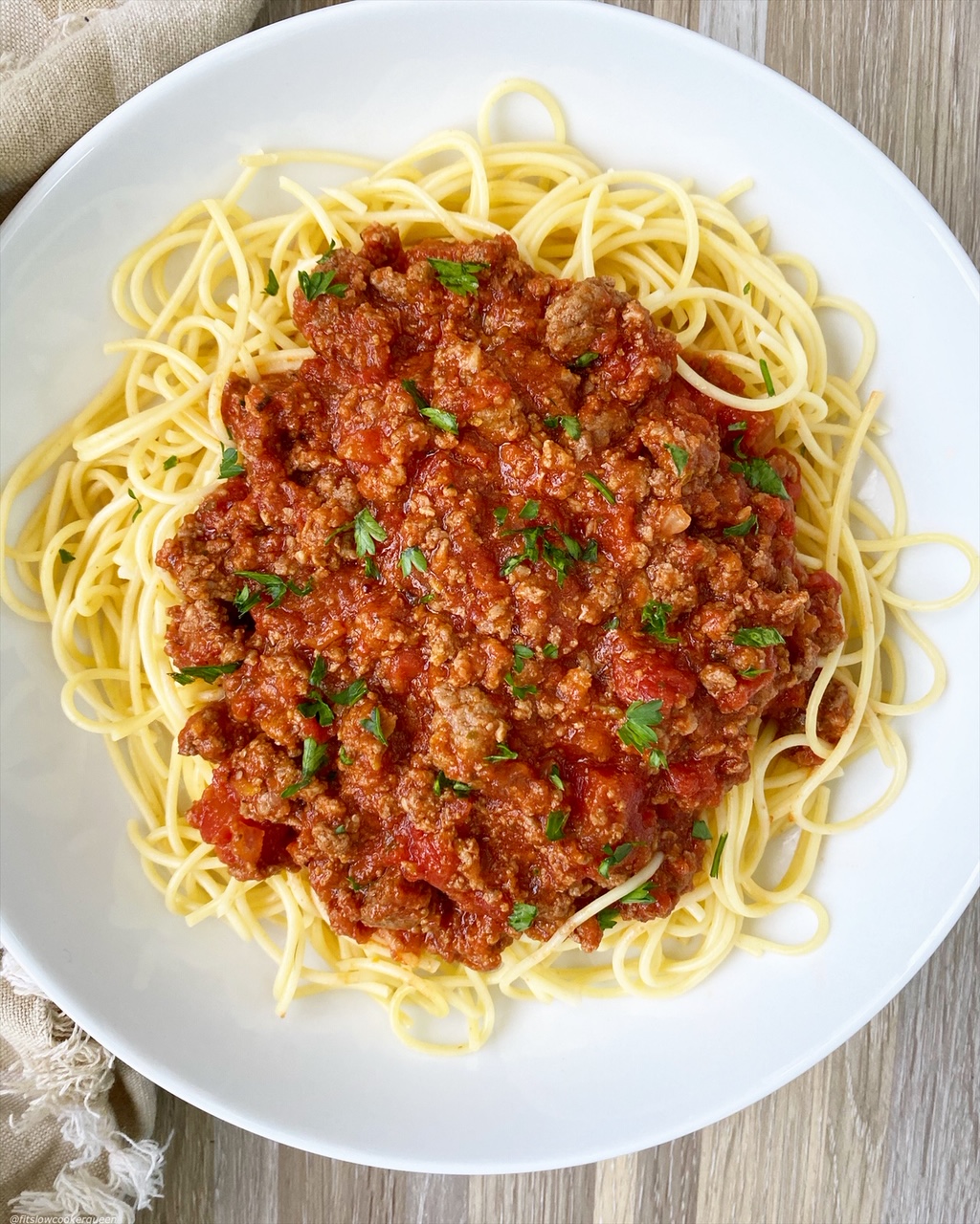 Slow Cooker Spaghetti Sauce on a white plate served over noodles
