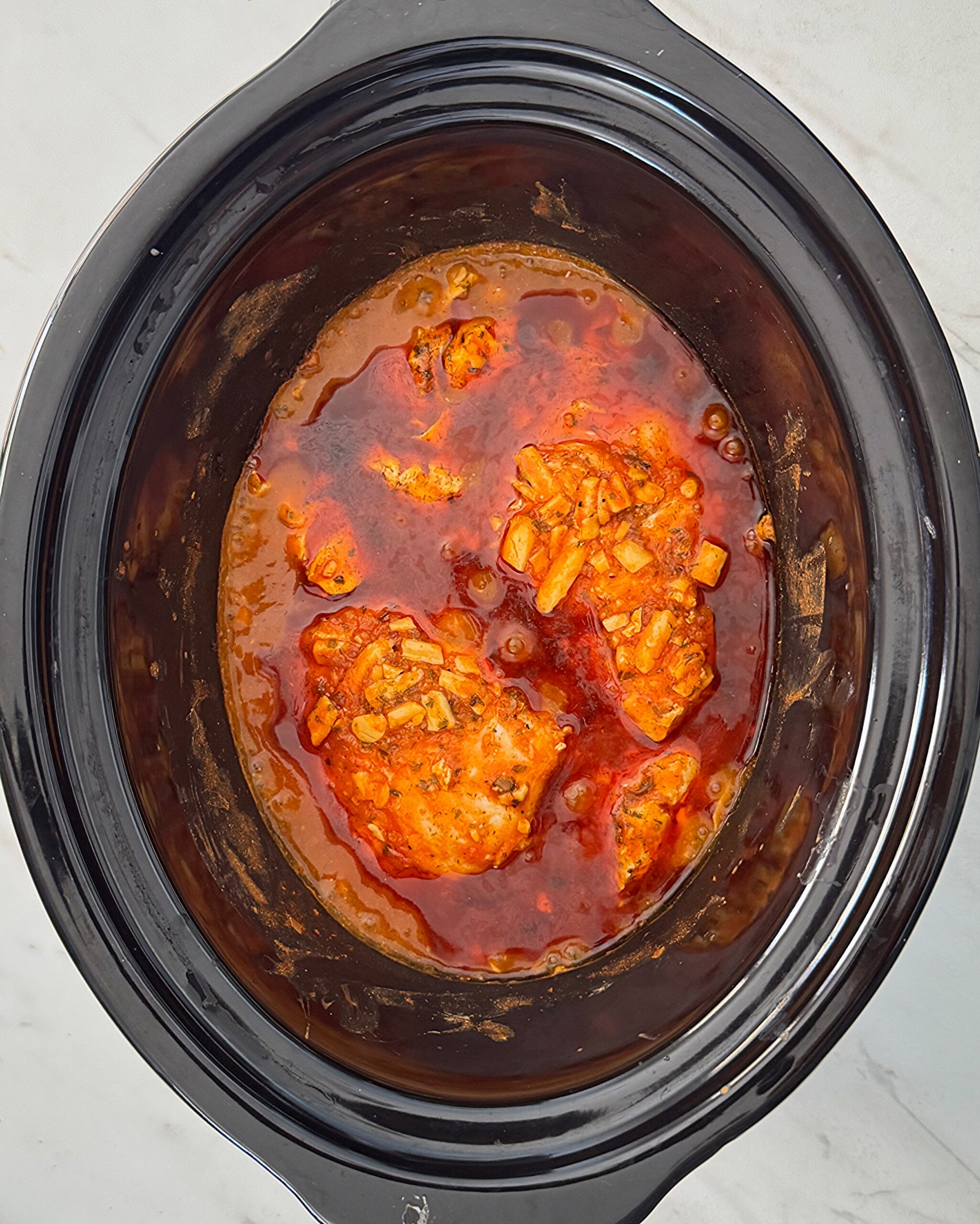 overhead shot of cooked Buffalo Chicken Dip in a black slow cooker
