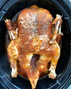 overhead shot of cooked duck in a black slow cooker