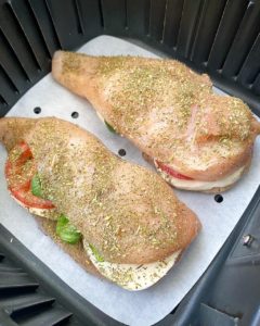 overhead shot of uncooked caprese stuffed chicken in the air fryer