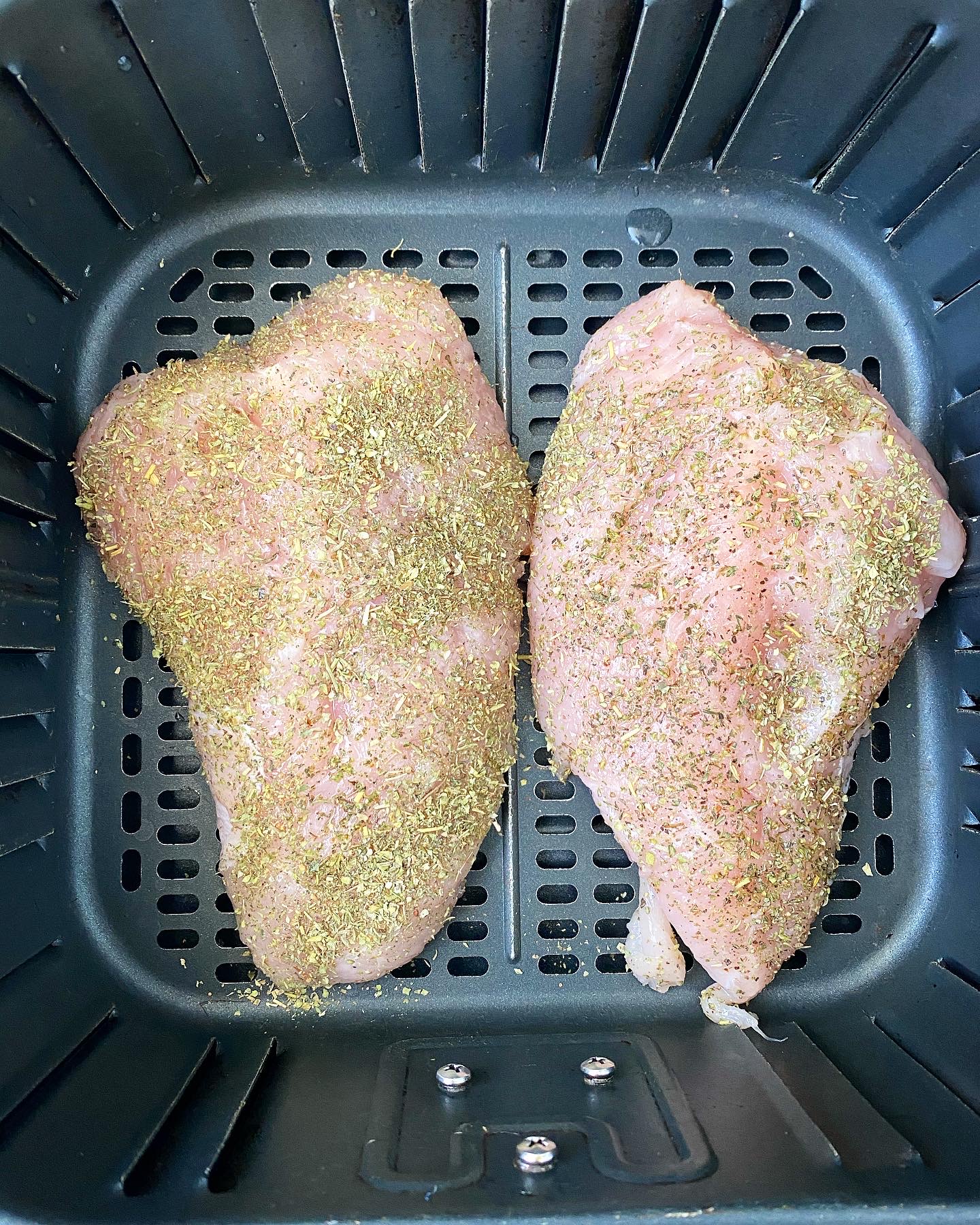 overhead shot of raw, seasoned turkey breast tenderloin in the air fryer