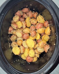 overhead shot of cooked Garlic Parmesan Potatoes in a black slow cooker