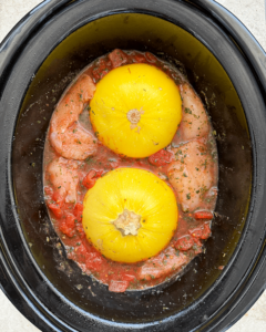 overhead shot of uncooked Spaghetti Squash and Chicken in a black slow cooker