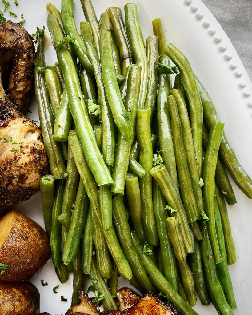 close up shot of cooked green beans on a white platter