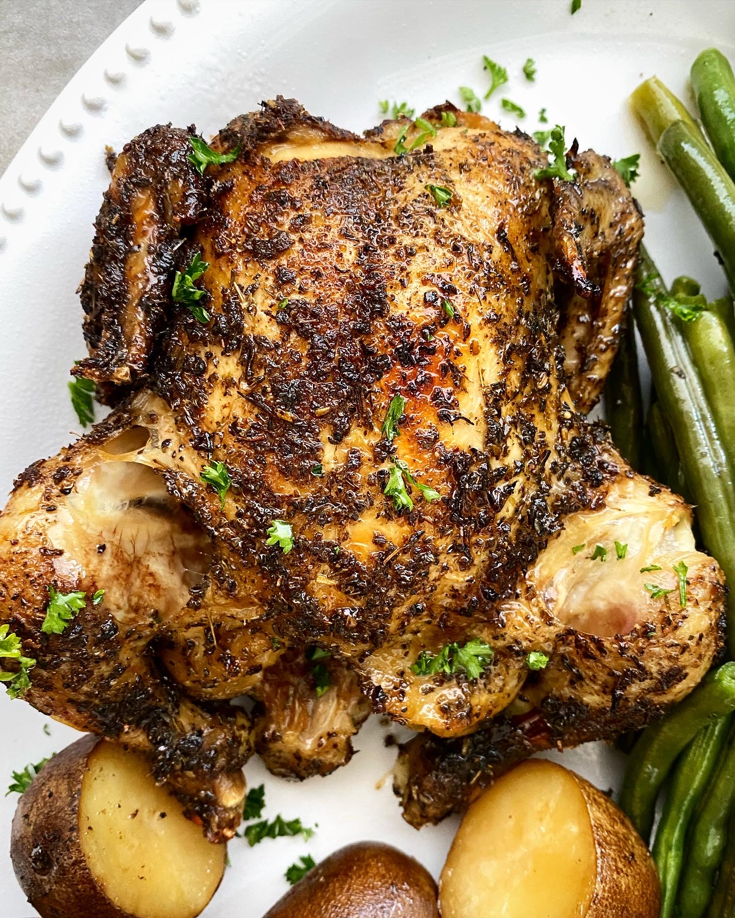 close up shot of a cooked Cornish hens, on a white platter