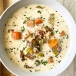 overhead shot of cooked turkey wild rice soup in a white bowl