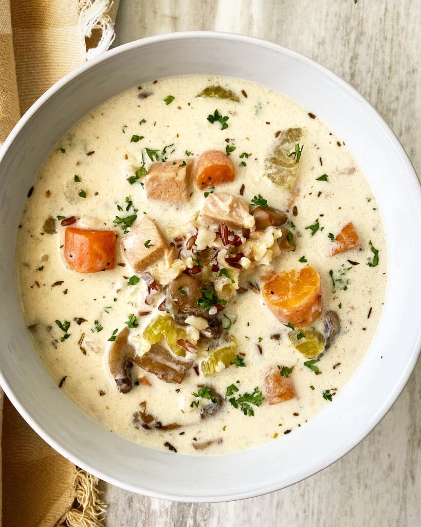 overhead shot of cooked turkey wild rice soup in a white bowl