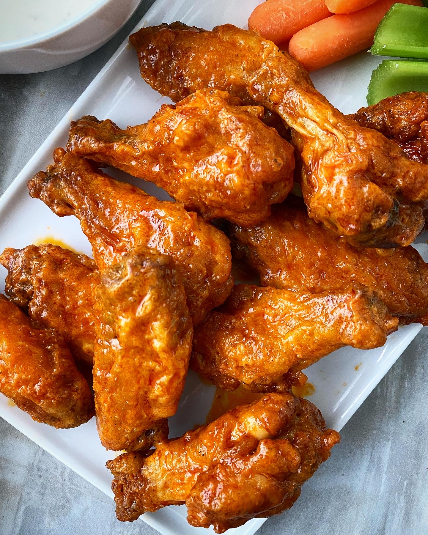 close up of air fryer buffalo chicken wings on a white plate