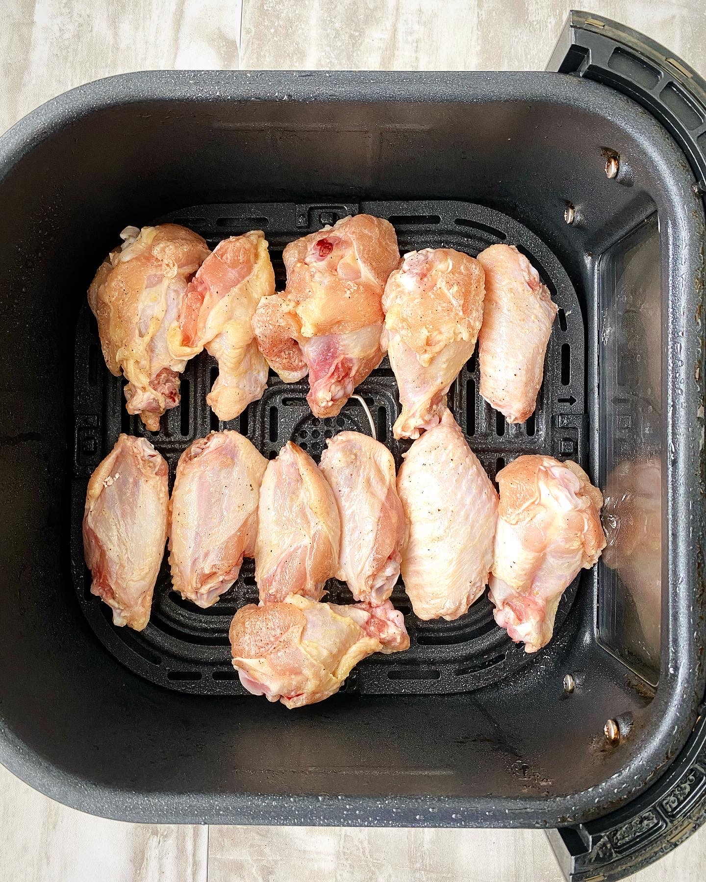 uncooked chicken wings in the air fryer basket