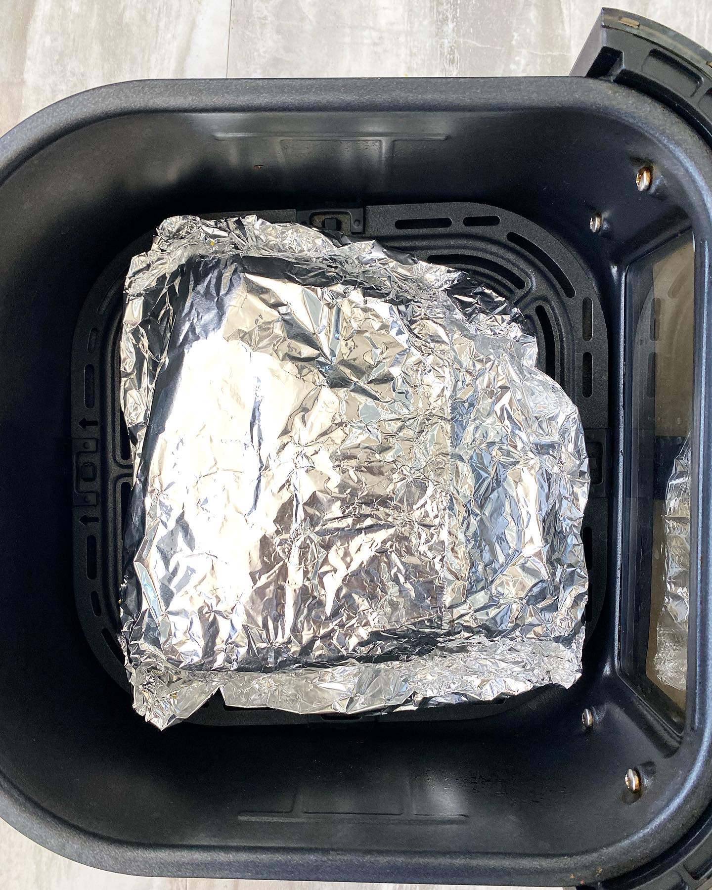 uncooked corned beef wrapped in foil in the air fryer
