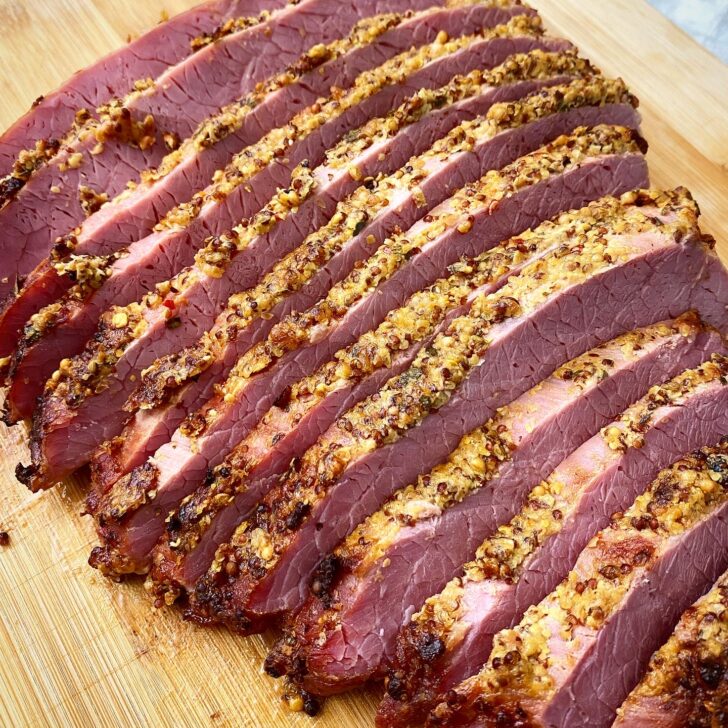 cooked & sliced corned beef on a cutting board