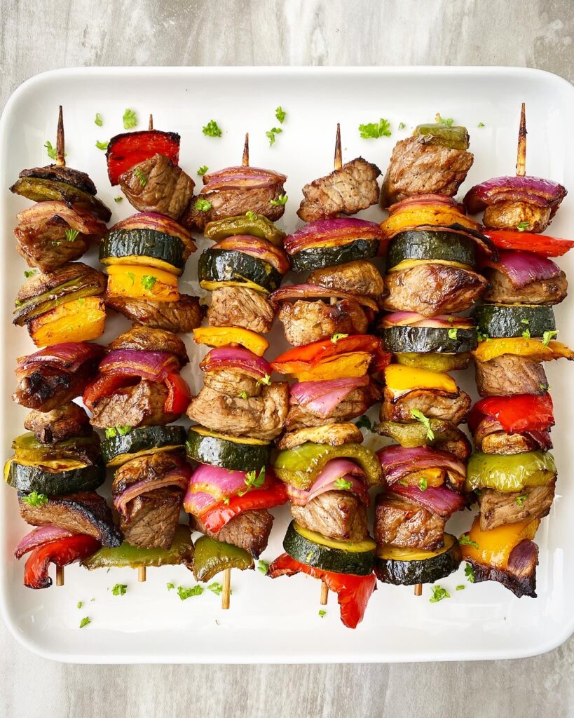 cooked Creole beef kebabs on a white plate