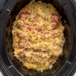 overhead shot of cooked hot dogs covered in sauerkraut a black slow cooker